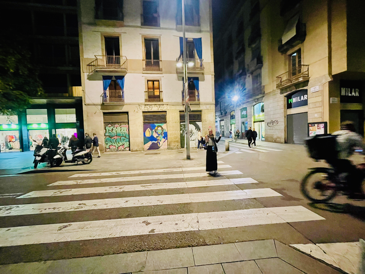 person standing in the road pointing to two vintage stores