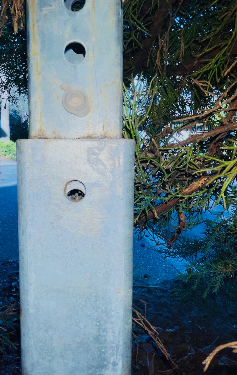 small plastic container hidden in a sign post